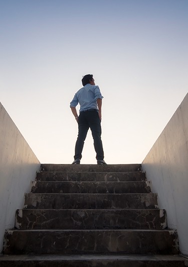 tkreiling consulting - Torsten Kreiling - Brücken bauen – Menschen bewegen - Mann steht oben auf einer Treppe und sieht in die Ferne